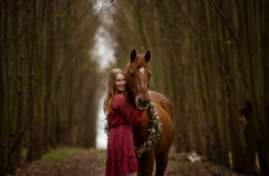 Pferd und Mädchen im Wald kuscheln